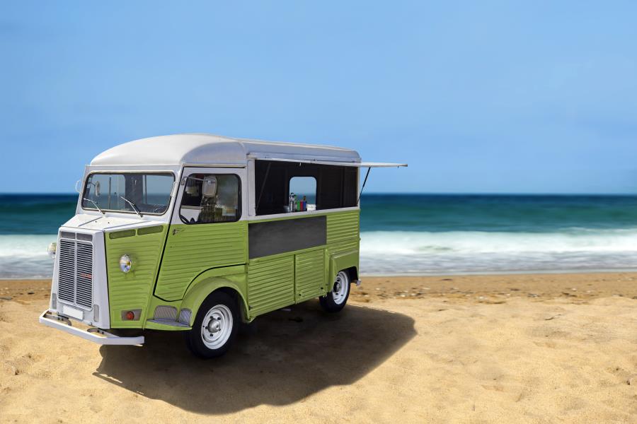 A vintage green van parked on a beach in Hollywood, FL.