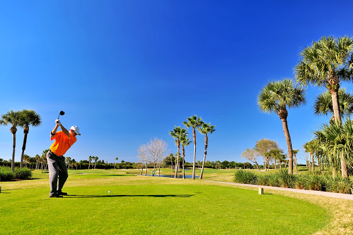 man swinging golf club on a sunny golf course