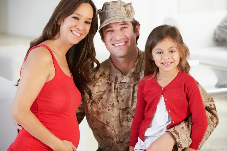 man in amilitary uniform posing with his young daughter and pregnant wife