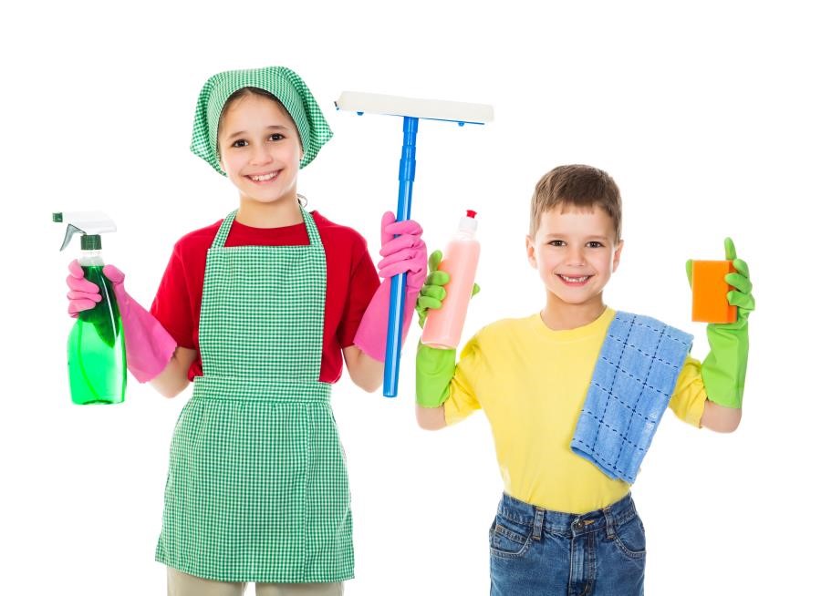 two children smiling while holding up cleaning equipment