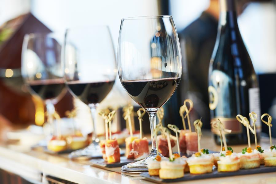 Several glasses of wine and food samples sitting on a table in a restaurant.