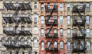 Small New York apartments with arched windows, fire escapes, and brick facade